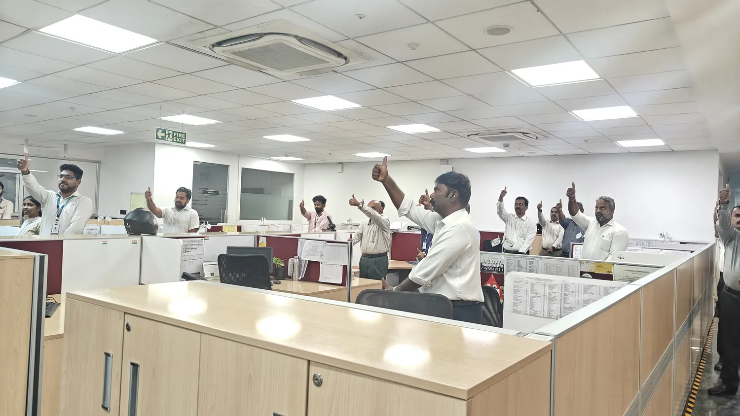 Office staff giving a thumbs-up during a workplace yoga session